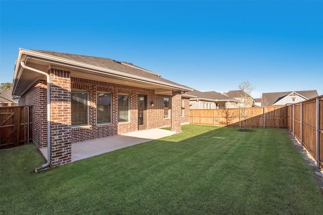 rear view of house featuring a yard and a patio area