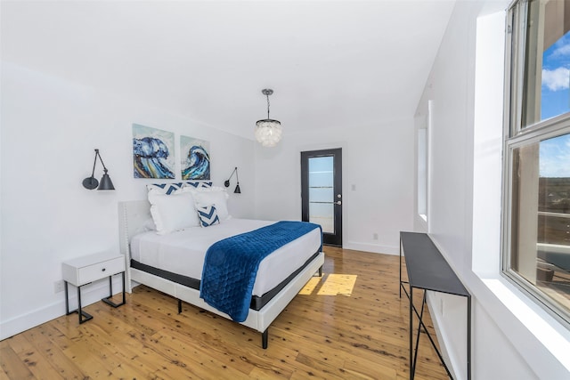 bedroom featuring a notable chandelier and light wood-type flooring