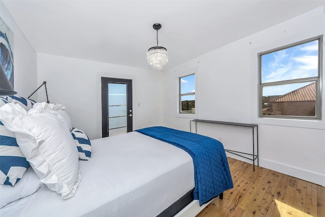 bedroom with hardwood / wood-style flooring and a chandelier