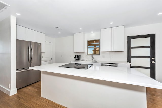 kitchen featuring a kitchen island, dark hardwood / wood-style floors, white cabinetry, sink, and stainless steel appliances