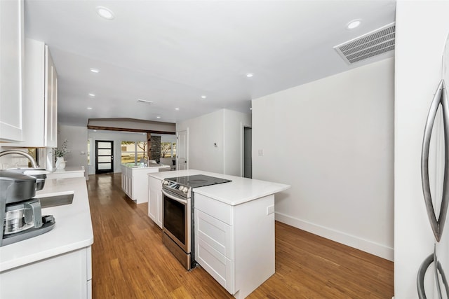 kitchen featuring light hardwood / wood-style flooring, stainless steel appliances, a center island, and white cabinets