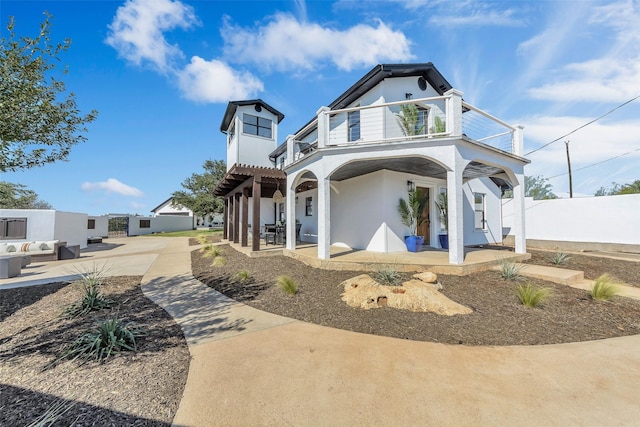 view of front of property featuring a patio and a balcony