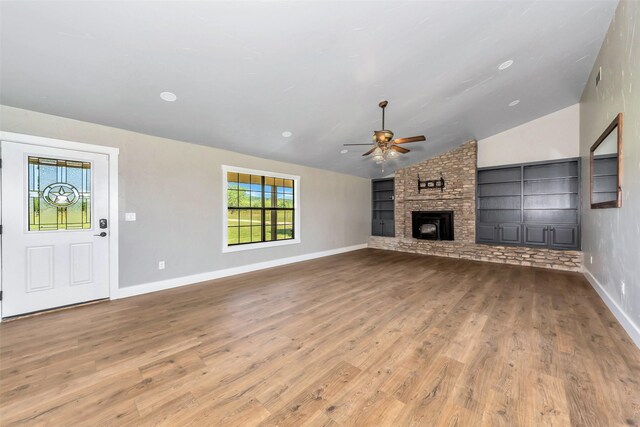 unfurnished living room featuring hardwood / wood-style floors, ceiling fan, a fireplace, and vaulted ceiling