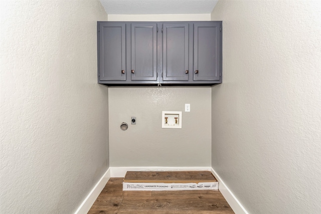 washroom featuring electric dryer hookup, cabinets, dark wood-type flooring, and hookup for a washing machine