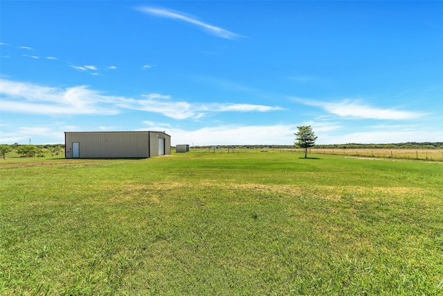 view of yard featuring a rural view and an outbuilding