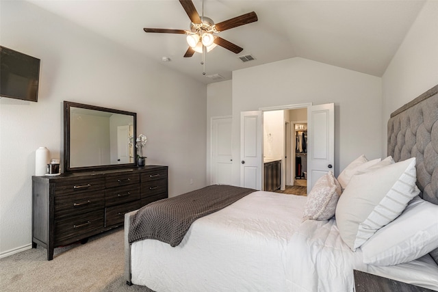 bedroom with ceiling fan, light colored carpet, lofted ceiling, and ensuite bathroom