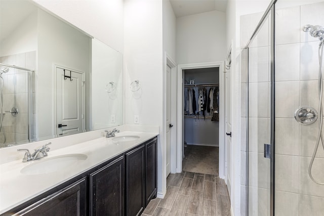 bathroom with vaulted ceiling, vanity, and a shower with shower door