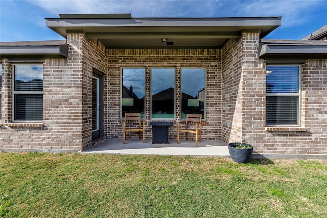 back of house with a patio and a lawn