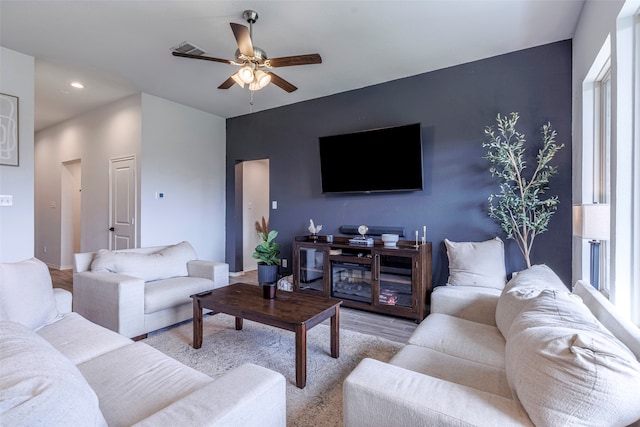 living room with ceiling fan and light hardwood / wood-style flooring