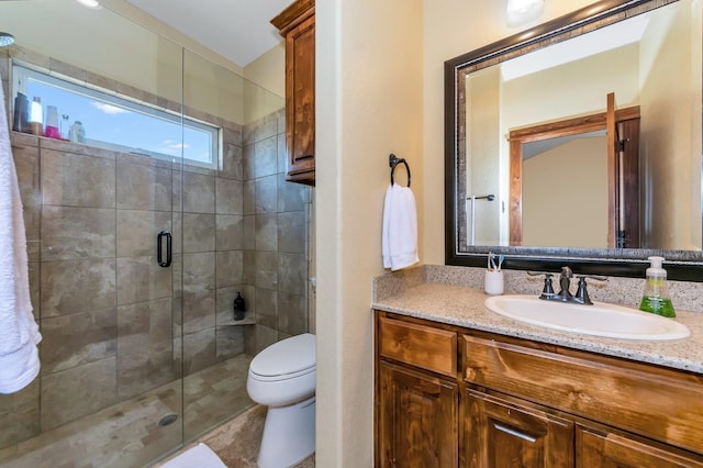 bathroom featuring vanity, toilet, and walk in shower