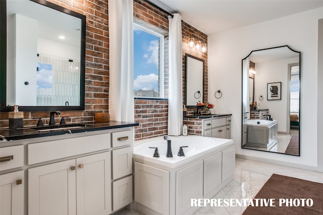 bathroom featuring vanity, a tub to relax in, and brick wall