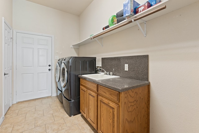 clothes washing area featuring washer and clothes dryer, sink, and light tile patterned flooring