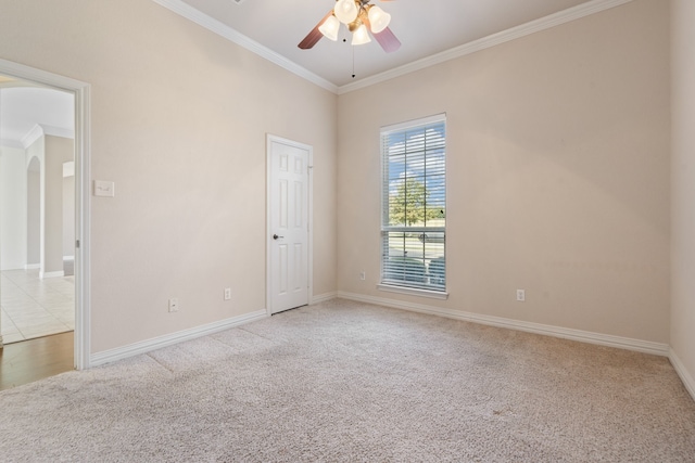 carpeted empty room featuring ceiling fan and crown molding