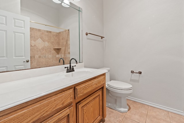 bathroom featuring tile patterned flooring, a tile shower, vanity, and toilet