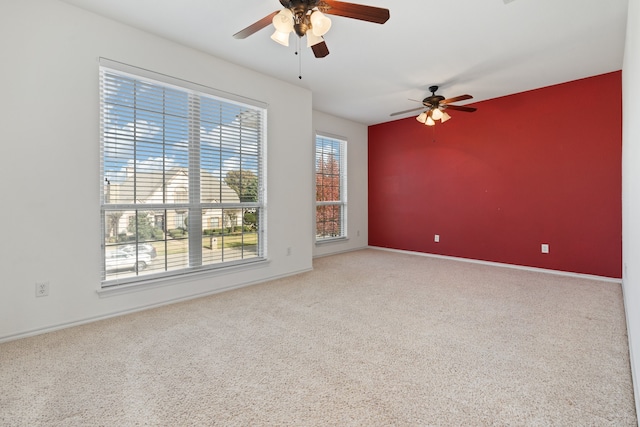 spare room featuring carpet floors, ceiling fan, and a healthy amount of sunlight