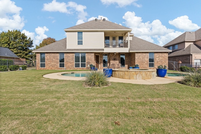 rear view of property with a balcony, a yard, and a fenced in pool