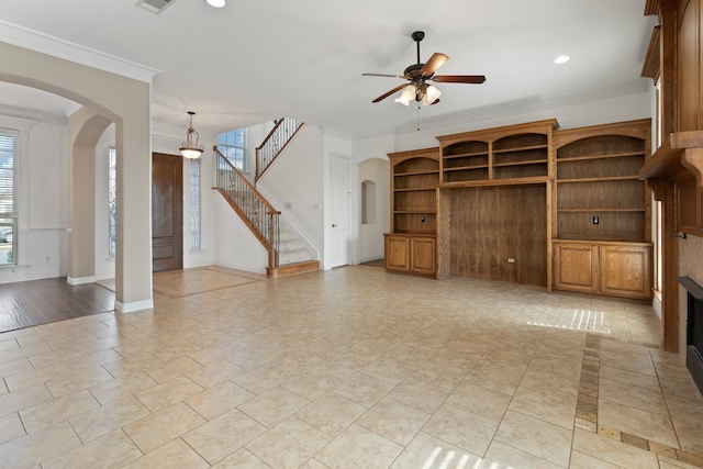 unfurnished living room featuring a fireplace, ceiling fan, and ornamental molding