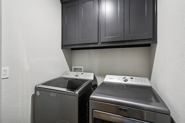 washroom with cabinets and washing machine and dryer