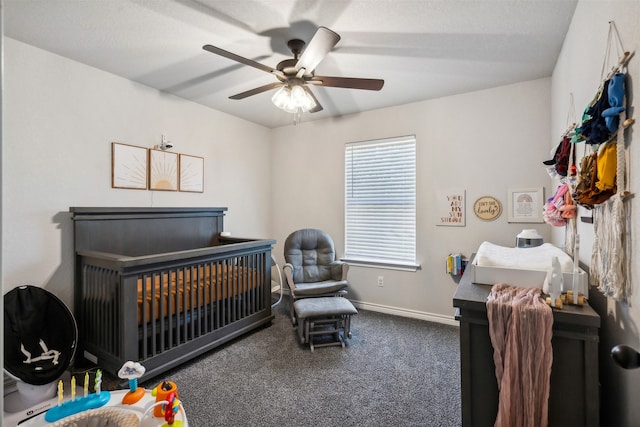 bedroom featuring carpet, ceiling fan, and a nursery area