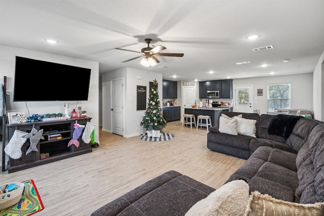 living room featuring ceiling fan and light wood-type flooring