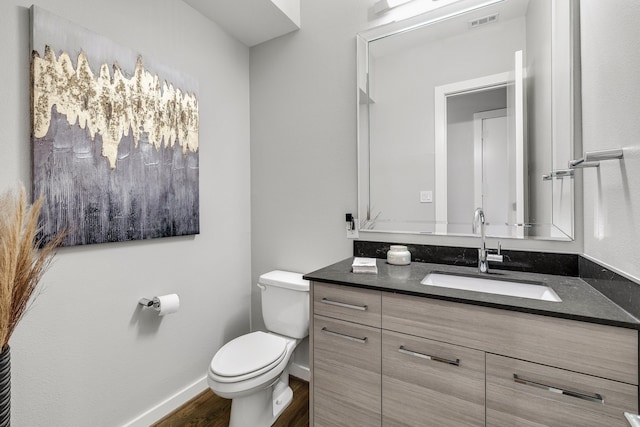 bathroom with hardwood / wood-style flooring, vanity, and toilet