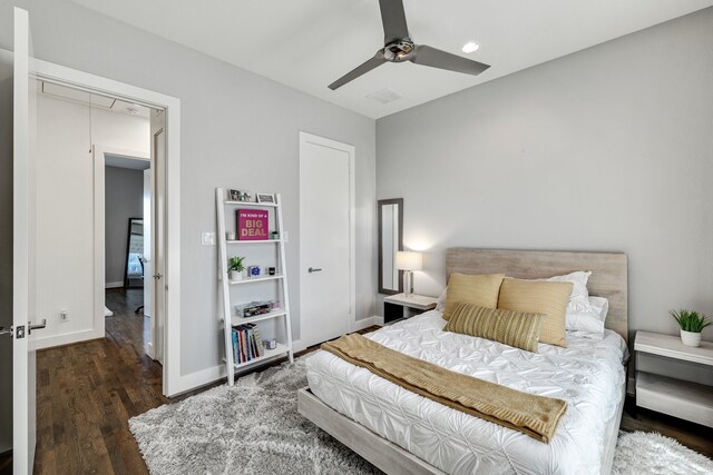 bedroom with a closet, dark hardwood / wood-style floors, and ceiling fan