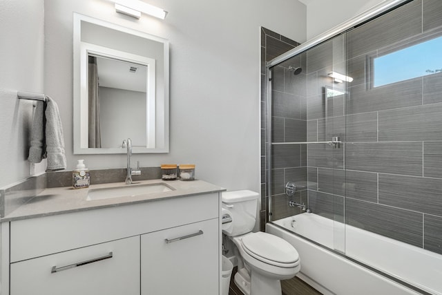 full bathroom with vanity, toilet, and bath / shower combo with glass door