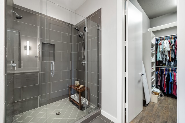 bathroom featuring an enclosed shower, wood-type flooring, and a textured ceiling