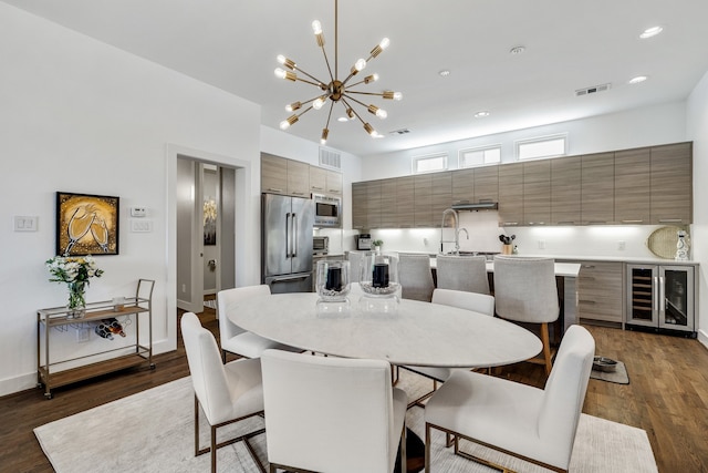 dining room with wine cooler, dark hardwood / wood-style floors, and an inviting chandelier