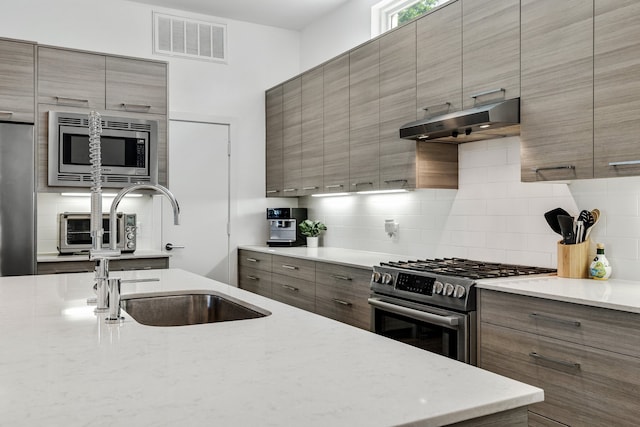 kitchen featuring decorative backsplash, sink, and stainless steel appliances