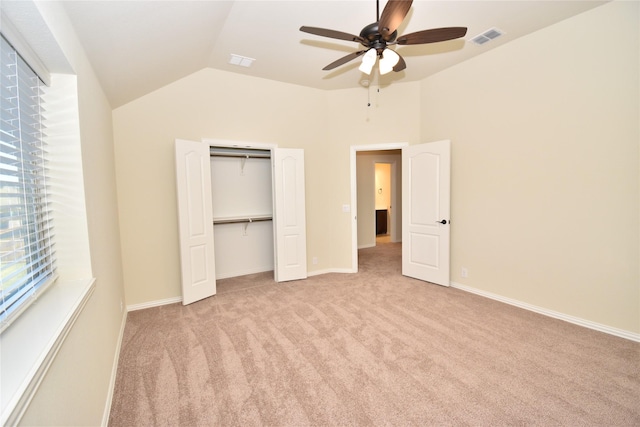 unfurnished bedroom featuring light carpet, a closet, ceiling fan, and lofted ceiling