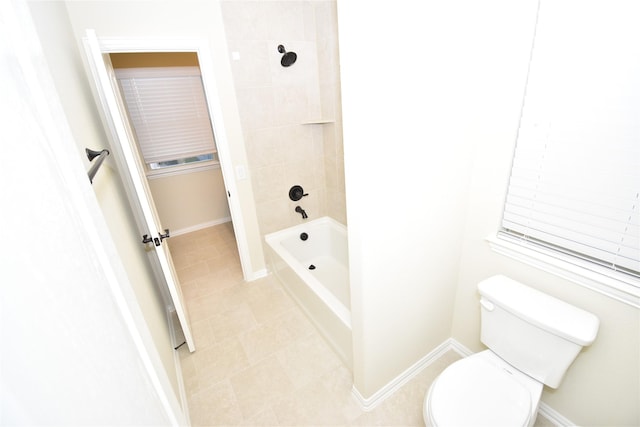 bathroom with tile patterned floors, tiled shower / bath combo, and toilet