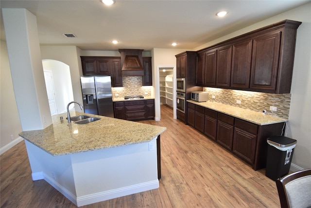 kitchen with decorative backsplash, sink, light hardwood / wood-style floors, and appliances with stainless steel finishes