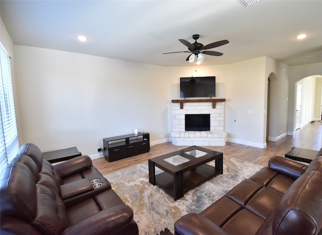 living room with ceiling fan, light hardwood / wood-style floors, and a fireplace