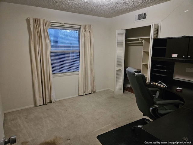 home office with light carpet and a textured ceiling