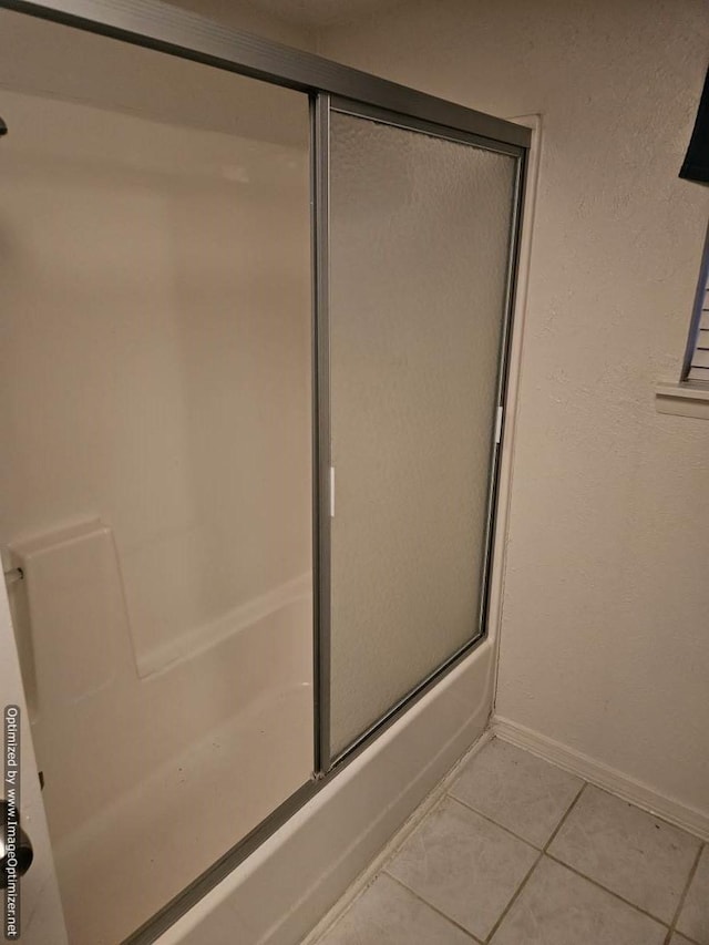 bathroom featuring tile patterned flooring and enclosed tub / shower combo