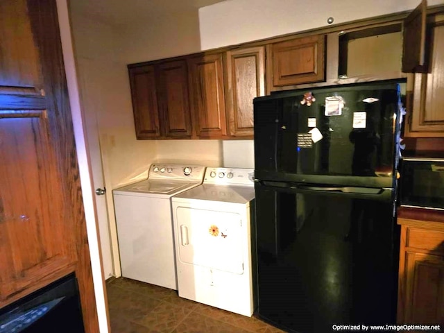 laundry area featuring washer and clothes dryer and dark tile patterned floors