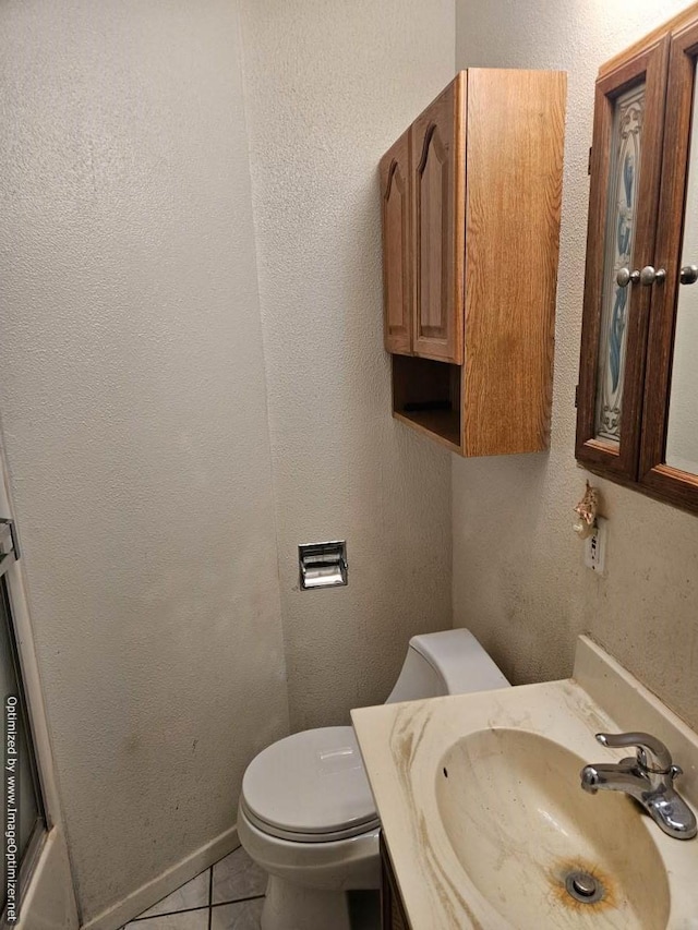 bathroom featuring tile patterned flooring, vanity, and toilet