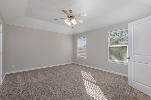 empty room with vaulted ceiling, ceiling fan, and carpet flooring