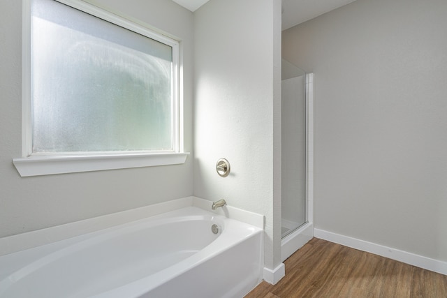 bathroom with hardwood / wood-style flooring and independent shower and bath