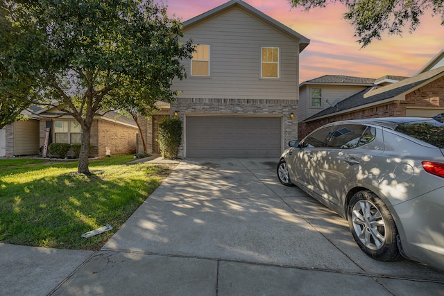 view of front of property featuring a yard and a garage