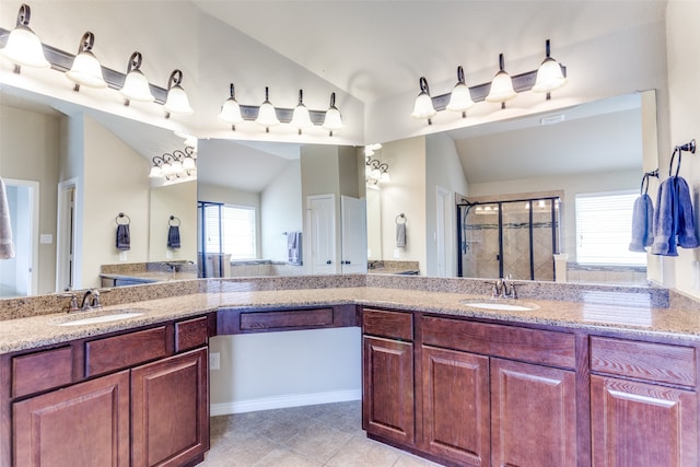 bathroom with tile patterned flooring, vanity, a shower with door, and vaulted ceiling