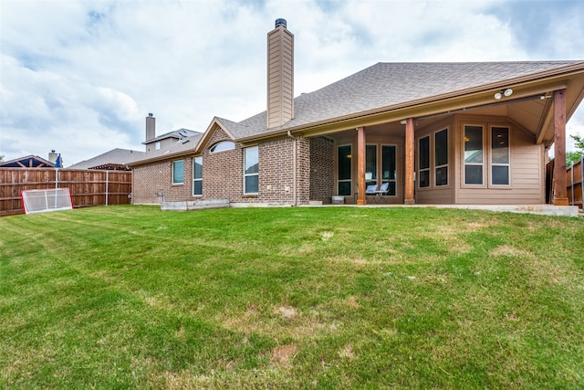 rear view of property featuring a lawn