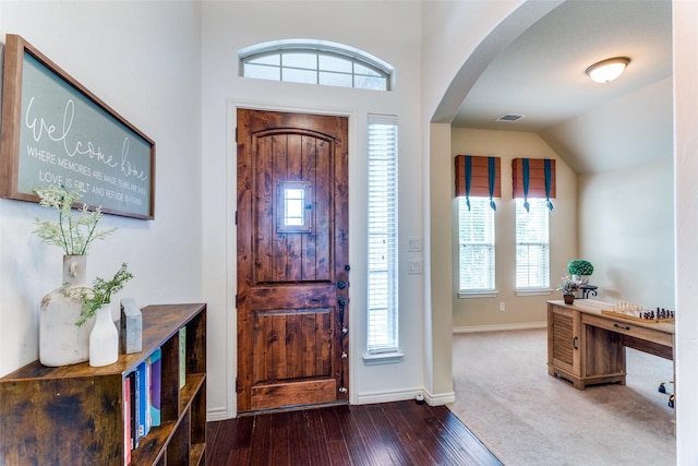 foyer entrance with wood-type flooring and vaulted ceiling