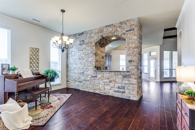 interior space with a chandelier, crown molding, and dark wood-type flooring