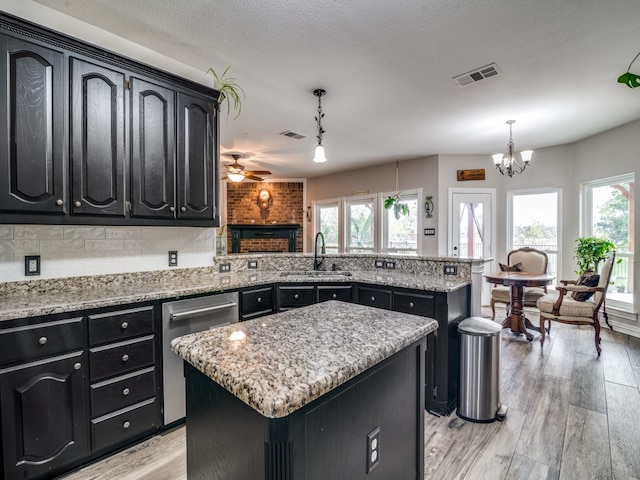 kitchen featuring hanging light fixtures, a center island, a wealth of natural light, and sink