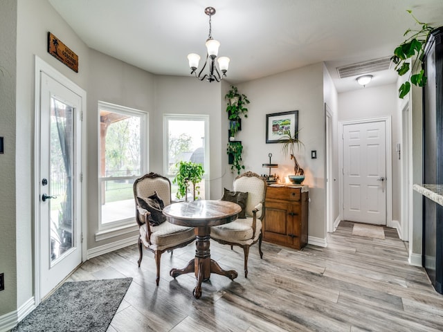 dining area with a chandelier and light hardwood / wood-style flooring