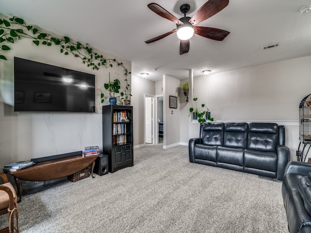 carpeted living room with ceiling fan