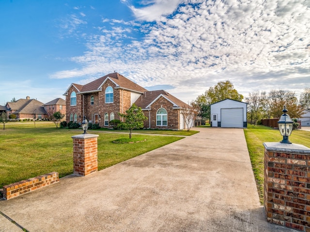 view of front of home featuring a garage, a front lawn, and an outdoor structure