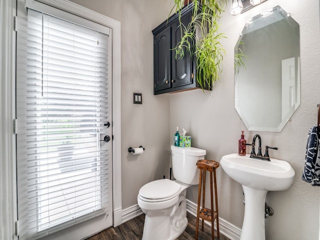 bathroom with toilet, wood-type flooring, and sink